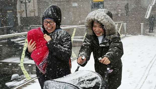People make their way through snow in Canary Wharf, London on Tuesday.