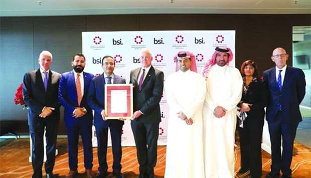 Al-Meer and the HIA team with Chamberlain, among others, during the ISO/IEC 20000:2011 certification award ceremony in Doha.