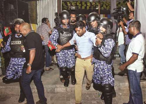 Maldivian police officers detaining an opposition protester, centre, demanding the release of political prisoners during a protest in Male last week.