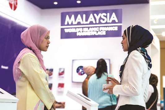 Delegates talk at the Malaysia International Islamic Financial Centre (MIFC) booth at the Global Islamic Finance Forum in Kuala Lumpur on September 3, 2014. Malaysiau2019s Islamic Financial Services Board (IFSB) is developing a detailed guidance on financial safety nets in case of insolvencies and bankruptcies to help harmonise Islamic principles with existing legal systems.