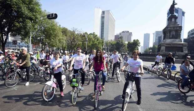 The vice chair of the Global Covenant of Mayors for Climate and Energy, Christiana Figueres (L), Mexico City Environment Secretary Tanya Muller (C), and the executive secretary of the United Nations Framework Convention on Climate Change, Patricia Espinosa (R), bike during a cycling event