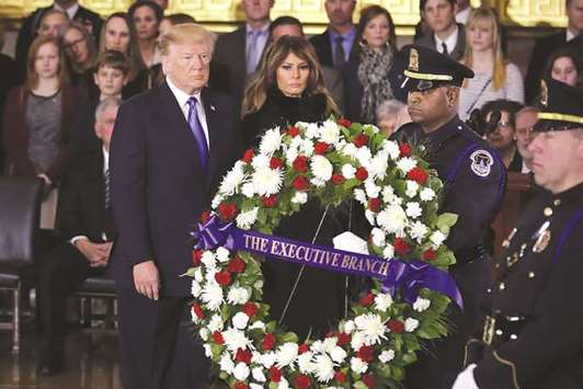 President Donald Trump and First Lady Melania Trump present a wreath at Christian evangelist and Southern Baptist minister Billy Grahamu2019s casket as he lies in honour in the US Capitol Rotunda in Washington, DC.