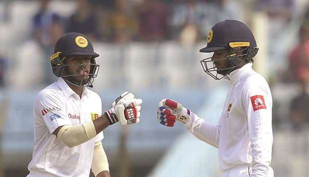 Sri Lanka batsmen Kusal Mendis (L) celebrates with his teammate Dhananjaya de Silva (R) after hitting a boundary during the third day of the first cricket Test between Bangladesh and Sri Lanka at Zahur Ahmed Chowdhury Stadium in Chittagong yesterday.