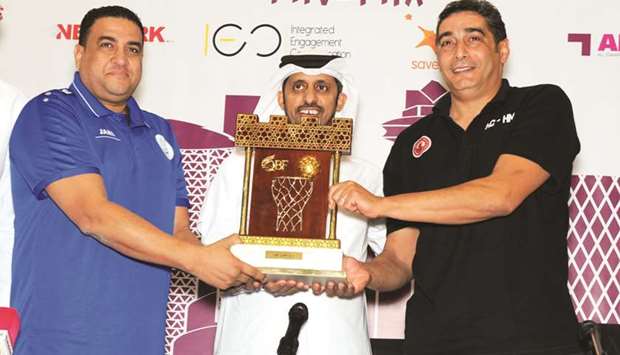 Al Arabi coach Hatem Mamlouk (L) and his Al Wakrah counterpart  Ihab Galal pose with the Qatar Menu2019s League trophy at their press conference. In the centre is QBF board member Abdulrahman al-Hitmi.