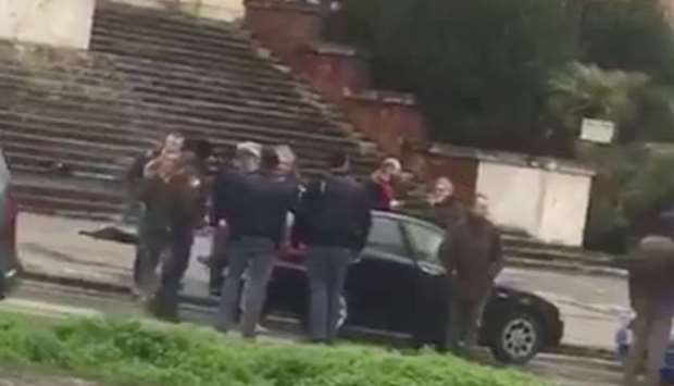 People gather where witnesses say a shooter was arrested in Macerata.