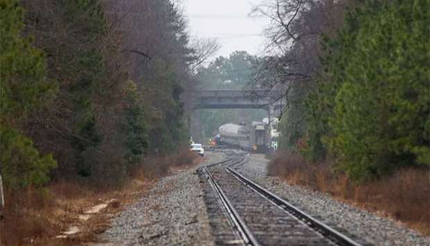 A derailed Amtrak car can be seen up the tracks near a crossing after an early morning collision with a CSX freight train in Cayce, South Carolina on Sunday.