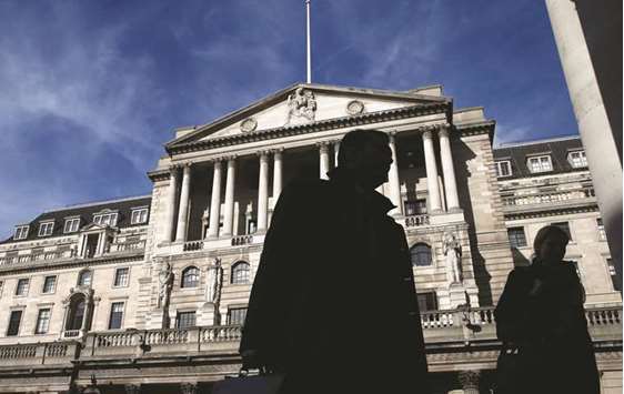 Pedestrians walking past the Bank of England in London. In a survey for Bloomberg, all but one of 17 economists see the BoE lifting its 2018 projection on Thursday, with the predictions for the next two years most likely to be left unchanged.
