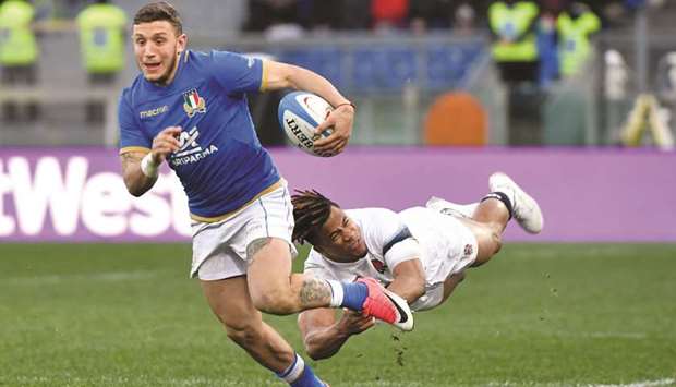 Italyu2019s fly-half Matteo Minozzi (left) attempts to evade Englandu2019s wing Anthony Watsonsu2019 tackle during the Six Nations rugby union match at the Olympic Stadium in Rome yesterday. (AFP)