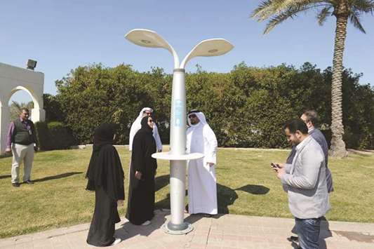  Officials inspect one of the solar lights installed in a park.