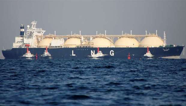 A LNG tanker is tugged towards a thermal power station in Futtsu