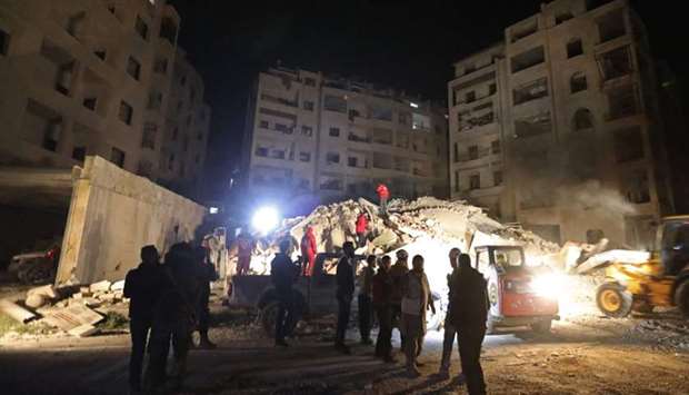 Syrian emergency services search for members of four families reportedly stuck under the rubble of a six story building that collapse following Syrian government air strikes on Idlib.