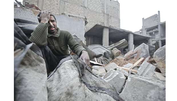 A Syrian man mourns over his destroyed home in the rebel-held besieged town of Arbin, in the eastern Ghouta region on the outskirts of the capital Damascus yesterday, following air strikes.