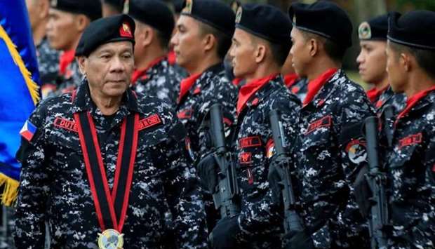 Philippine President Rodrigo Duterte, wearing a military uniform, reviews scout ranger troops
