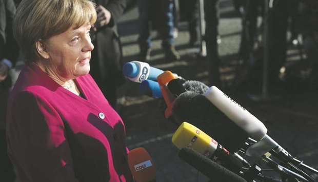 German Chancellor Angela Merkel gives a statement as she arrives for further talks to form a new government in Berlin.