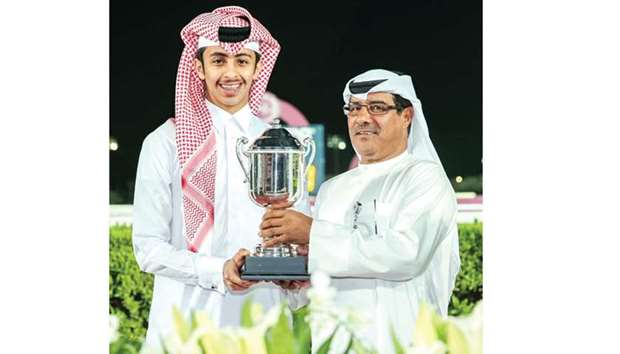 QREC deputy chief steward Abdulla Rashid al-Kubaisi (right) presents the trophy to Khalifa bin Sheail al-Kuwari after Anima Rock won the Marmi Cup yesterday. PICTURE: Juhaim