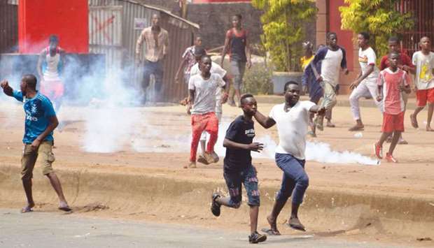 People clash with riot police during a demonstration against the results of the local elections in Conakry on Tuesday.