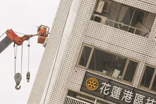 A rescue worker searches for survivors at a damaged building after an earthquake hit Hualien, Taiwan.
