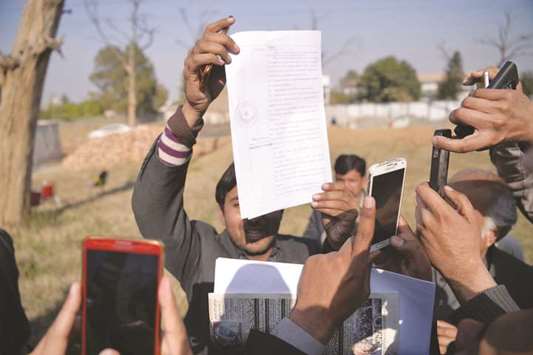 Local journalists take images of the court verdict against suspects accused in a blasphemy lynching case outside the central jail in Haripur district, 120km from Islamabad, yesterday.