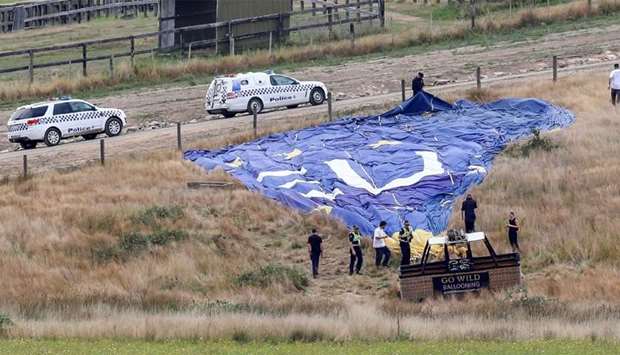 Police inspect a hot air balloon after it crashed during a dawn tour at Dixons Creek, some 60 kilometres (37 miles) north of Melbourne