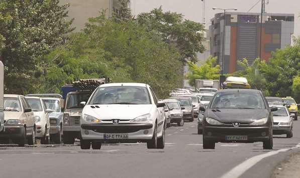 File photo taken on July 24, 2012 shows Iranians driving locally-manufactured Peugeot 206 cars in the streets of Tehran. France, which has had close business  ties with Iran since before the fall of the Shah in 1979 and operates large factories there including Renault and PSA plants, has sought to deepen trade ties since sanctions were lifted.