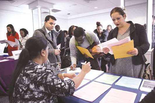 A New York Department of City Administrative Services representative (left) speaks with job seekers during a Catalyst Career Group job fair in New York on Wednesday. Initial claims for state unemployment benefits decreased 9,000 to a seasonally adjusted 221,000 for the week ended February 3, the Labour Department said yesterday.
