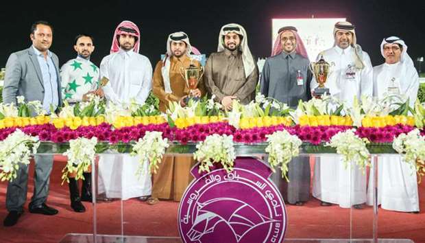 Qatar Racing and Equestrian Club (QREC) general manager Nasser Sherida al-Kaabi (fourth from right) and deputy chief steward Abdulla al-Kubaisi (right) with the winners of the Al Wajba Cup after Topsy Turvy won the feature yesterday. PICTURE: Juhaim