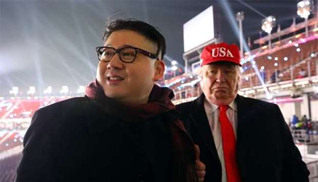 People dressed up as US President Donald Trump and North Korean leader Kim Jong Un attend the Winter Olympics opening ceremony in Pyeongchang, South Korea on Friday.