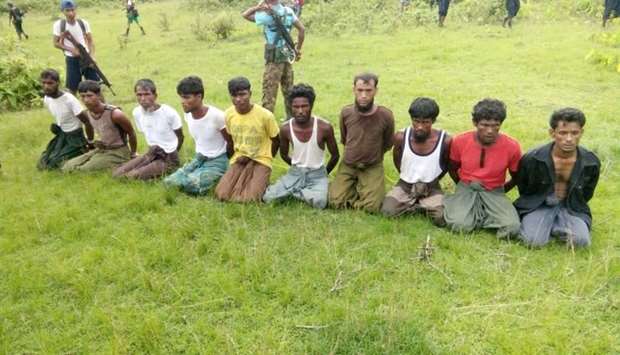..Ten Rohingya Muslim men with their hands bound kneel as members of the Myanmar security forces stand guard in Inn Din village September 2, 2017
