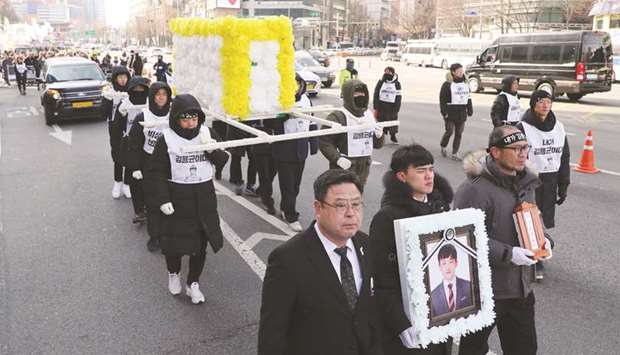 People march to honour a worker crushed to death at a coal plant, in Seoul yesterday.