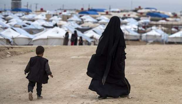 A displaced Syrian woman and a child walk toward tents at the Internally Displaced Persons (IDP) camp of al-Hol in al-Hasakeh governorate in northeastern Syria