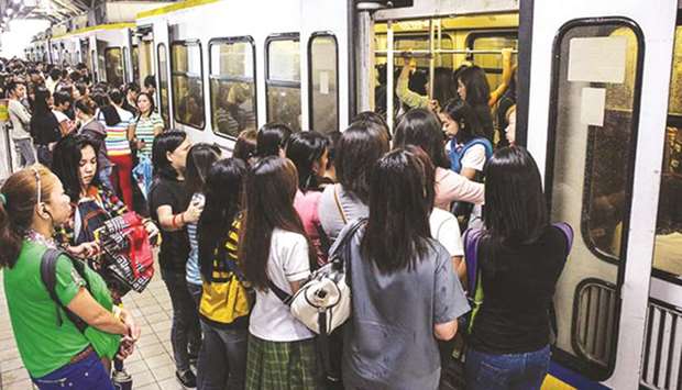 Passengers board a train at the Doroteo Jose station of LRT in Manila.
