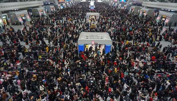 Crowds of travelers walk through a hall at a railway station in Hangzhou in China's eastern Zhejiang province on the last day of the Spring Festival holiday