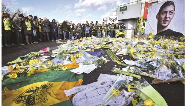 FC Nantes supporters gather in front of a portrait of late Argentinian forward Emiliano Sala to pay tribute prior to the French L1 match between FC Nantes and Nimes Olympique at the La Beaujoire stadium in Nantes, western France, yesterday. (AFP)