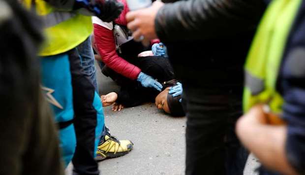 Street medics provide first aid to a woman lying on the ground during an anti-government demonstration called by the ,yellow vests, (gilets jaunes) movement in Lyon.