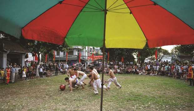 Vietnamese men wrestling for the prized jackfruit wooden ball during the traditional u201cVat Cauu201d or ball wrestling festival on the fifth day of Lunar New Year celebrations, referred to in Vietnam as Tet, at Thuy Linh pagoda in Hanoi.