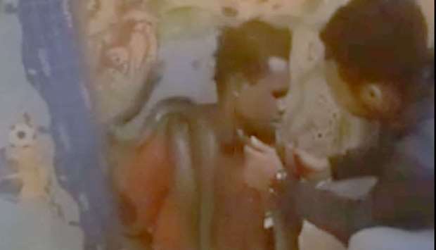 An image grab from a video uploaded on YouTube that shows the accused man with a live snake around his neck and a policeman taking the snake's head near his face