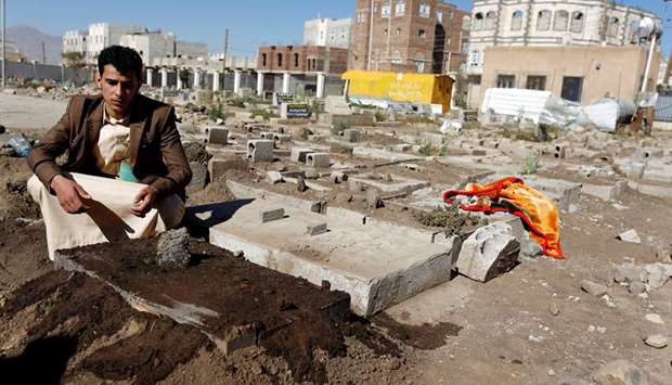 Akram al-Bahshani sits next to the grave of his conjoined twins Abd al-Khaleq and Abd al-Rahim, after their burial at a graveyard in Sanaa.