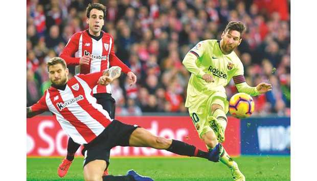 Barcelonau2019s Argentinian forward Lionel Messi (right) shoots past Athletic Bilbaou2019s Spanish defender Inigo Martinez during the La Liga match at the San Mames stadium in Bilbao on Sunday night. (AFP)