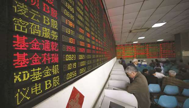 Investors look at computer screens showing stock information at a brokerage house in Shanghai. The Composite index closed up 1.4% to 2,653.90 points yesterday.