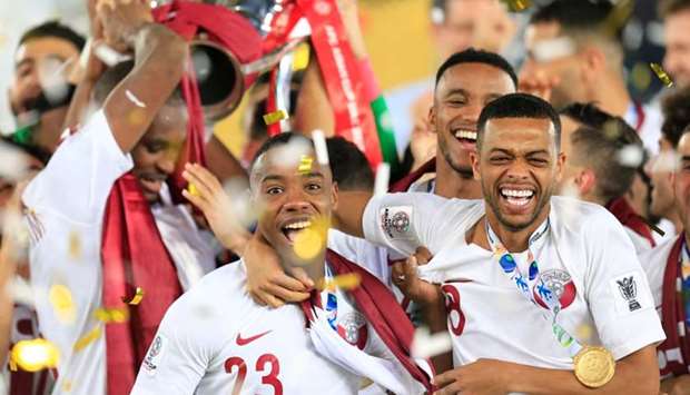 Qatar's Assim Madebo and team mates celebrate with the trophy after winning the Asian Cup