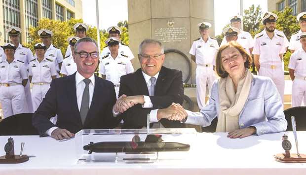 From left: Australian Defence Minister Christopher Pyne, Australian Prime Minister Scott Morrision and French Defence Minister Florence Parly shake hands after signing the attack-class submarine Strategic Partnering Agreement in Canberra, Australia.