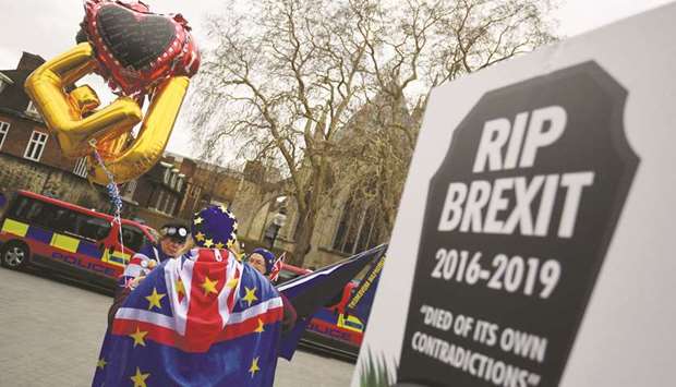Anti-Brexit protestors hold placards, flags and banners outside of the Houses of Parliament in London yesterday.