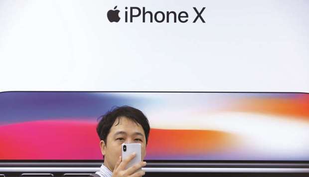 An attendee uses a new iPhone X during a presentation for the media in Beijing (file). Appleu2019s Chinese smartphone shipments plummeted an estimated 20% in 2018u2019s final quarter.