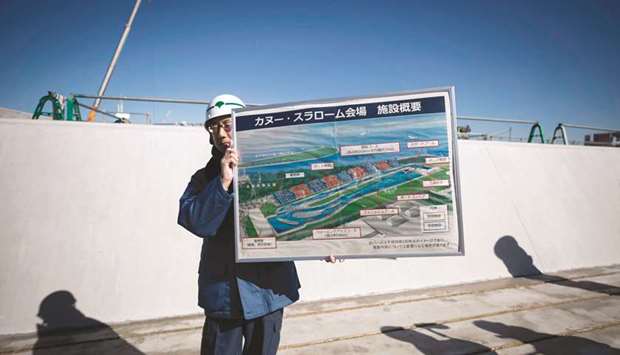 An employee holds an image of the course at the under construction Kasai Canoe Slalom Centre in Tokyo yesterday. (AFP)