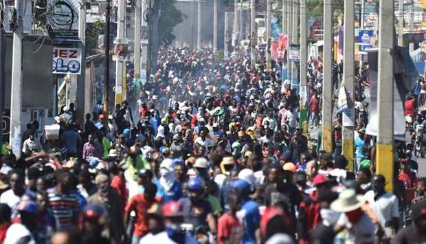 Demonstrators march on the streets on the fifth day of protests in Port-au-Prince, yesterday against Haitian President Jovenel Moise and the misuse of Petrocaribe funds