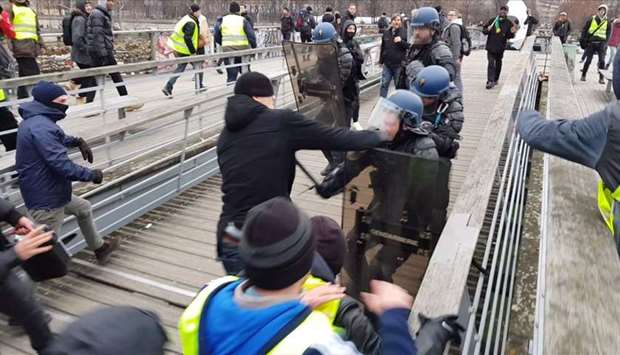 In this file video grab made on January 7, 2018 shows a man (C) believed to be Christophe Dettinger as he takes a boxing stance while clashing with riot police during a demonstration by ,Gilets Jaunes, anti-government protestors on a bridge leading to the National Assembly in Paris on January 5, 2019. AFP
