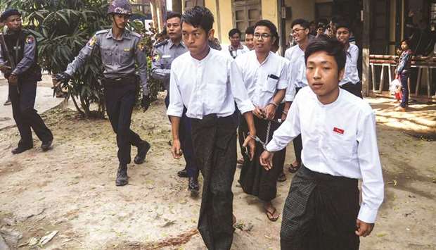 Students are escorted by police after a court hearing in Mandalay yesterday.