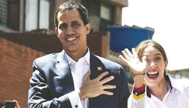 Venezuelan opposition leader and self declared acting president Juan Guaido (left), accompanied by his wife Fabiana Rosales, gestures at supporters upon arriving at a rally to press the military to let in US humanitarian aid, in eastern Caracas on February 12.