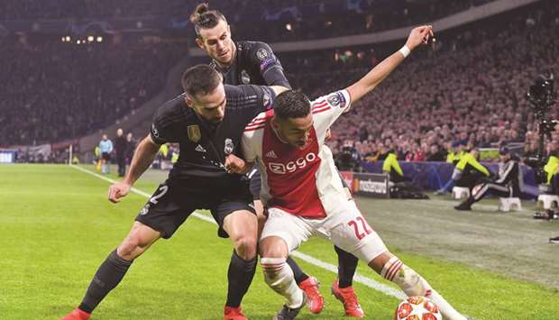 Ajaxu2019s midfielder Hakim Ziyech (right) vies for the ball with Real Madridu2019s defender Dani Carvajal (left) and forward Gareth Bale (centre) during the Champions League round of 16 first leg match at the Johan Cruijff Arena in Amsterdam. (AFP)