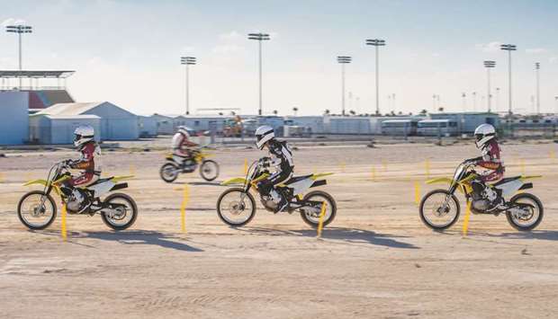 Women participants take part in a racing session at the Qatar Motorsports Academy at Losail Circuit.